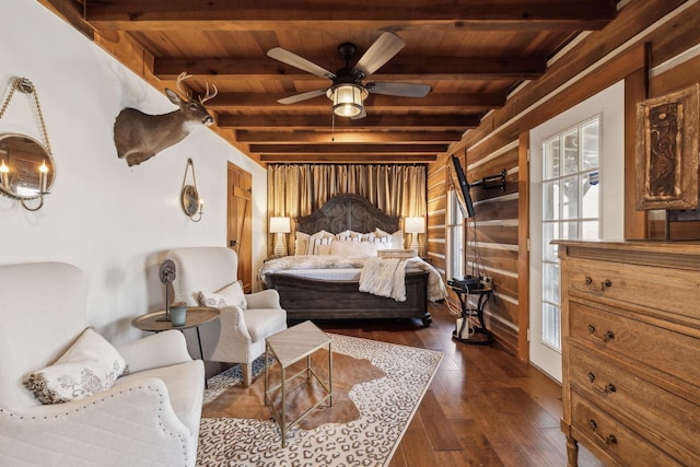 bedroom with beamed ceiling, wood walls, wood ceiling, and dark wood-style flooring