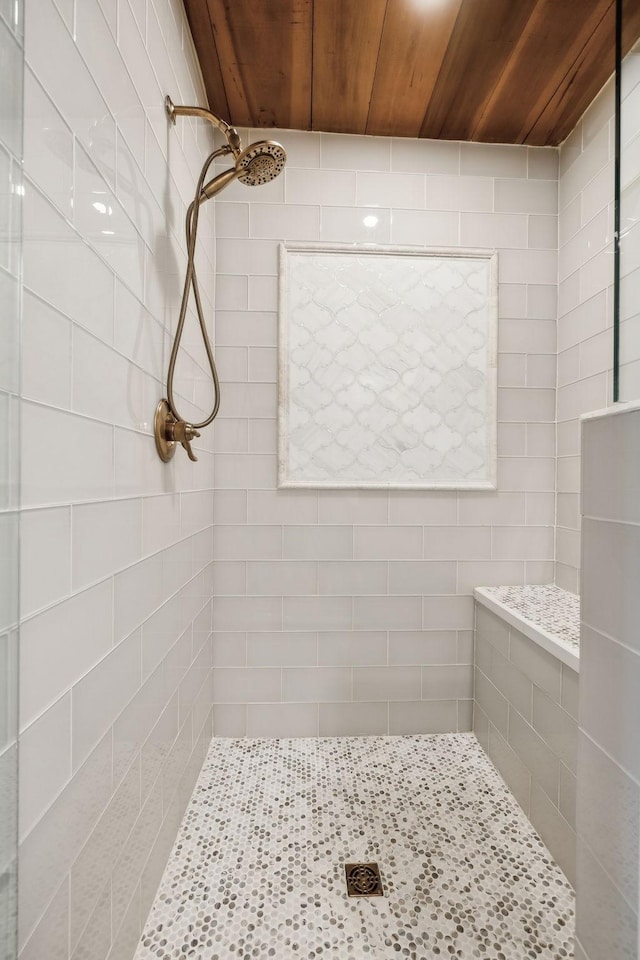 full bathroom featuring tiled shower and wooden ceiling