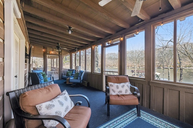 sunroom / solarium featuring beam ceiling and ceiling fan