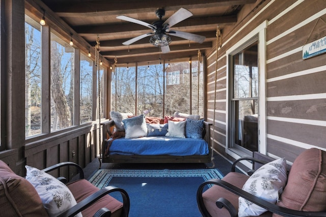 sunroom / solarium with beamed ceiling and a ceiling fan