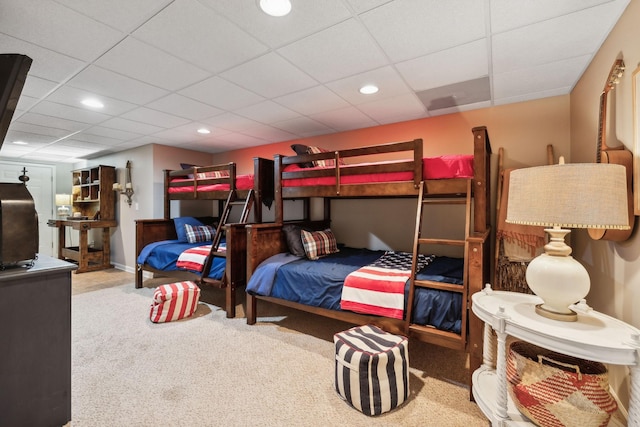 carpeted bedroom featuring recessed lighting and a drop ceiling