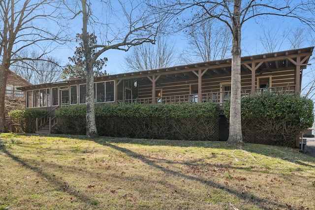 rear view of property with a yard and a sunroom