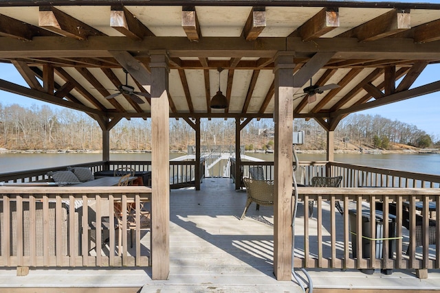 deck with a gazebo, a water view, and ceiling fan