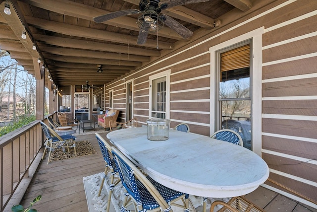 wooden deck featuring outdoor dining area and a ceiling fan
