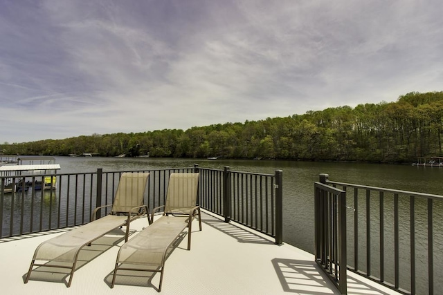 view of dock with a forest view and a water view