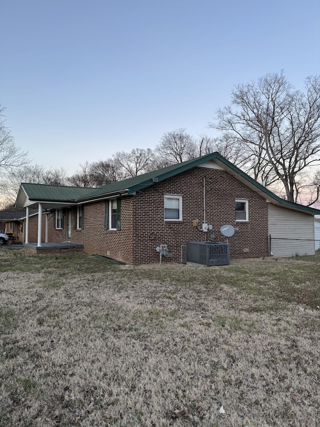 view of property exterior featuring a yard, cooling unit, an attached garage, crawl space, and brick siding