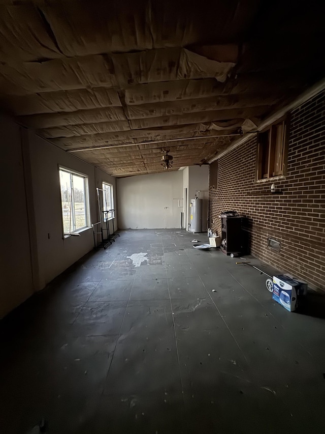 miscellaneous room with water heater and brick wall