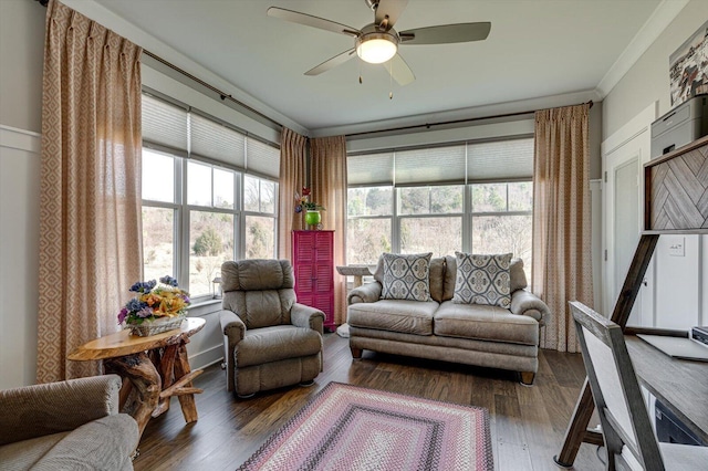 living area with a ceiling fan, wood finished floors, and crown molding