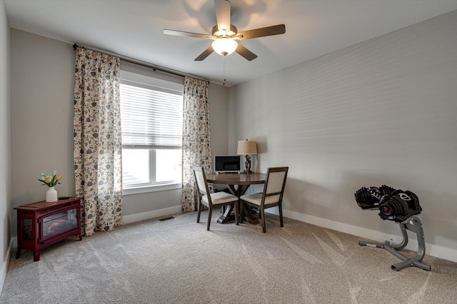 carpeted office space with visible vents, baseboards, and a ceiling fan