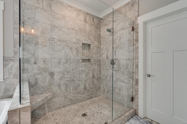 full bath featuring a shower stall, a washtub, and ornamental molding