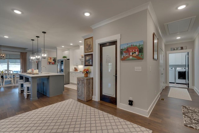 kitchen featuring crown molding, dark wood finished floors, light countertops, a kitchen breakfast bar, and freestanding refrigerator