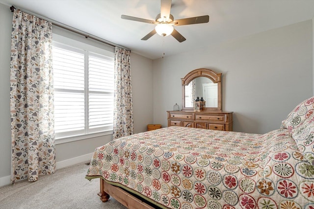 carpeted bedroom with ceiling fan and baseboards