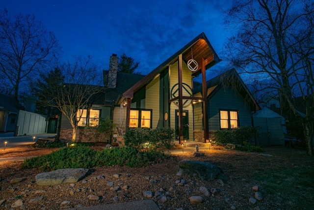 view of front of home featuring stone siding and a chimney