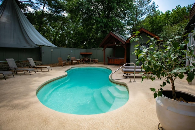 view of pool featuring a patio, fence, a fenced in pool, and a hot tub