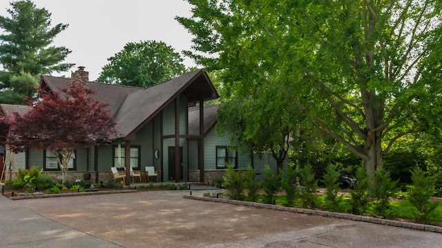 view of front of property featuring stone siding and a chimney