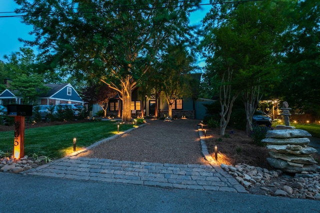 view of front facade featuring stone siding, driveway, and a front yard