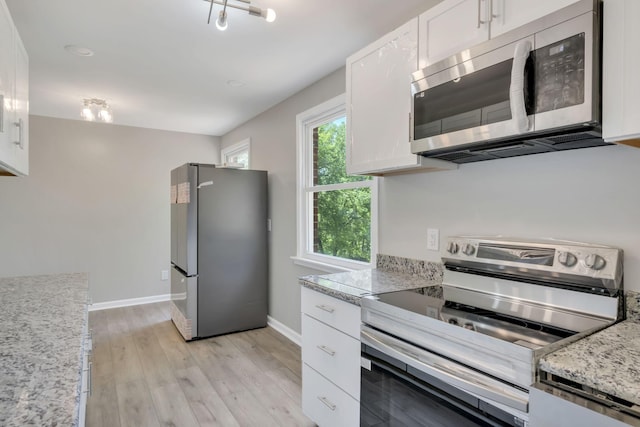 kitchen featuring light stone countertops, baseboards, appliances with stainless steel finishes, white cabinetry, and light wood-type flooring