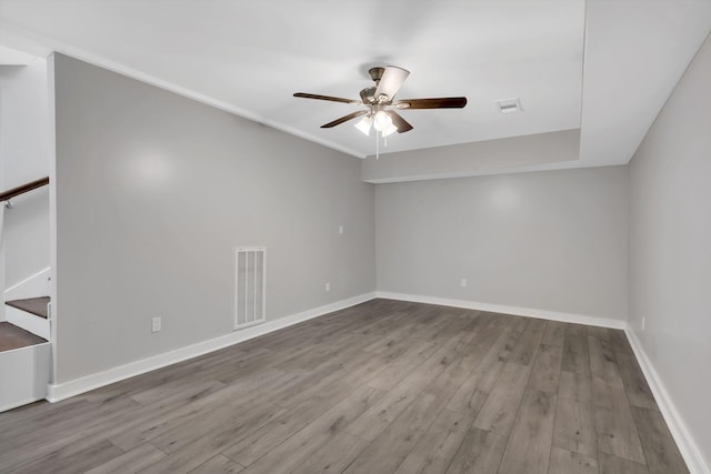 unfurnished room featuring ceiling fan, visible vents, baseboards, and wood finished floors