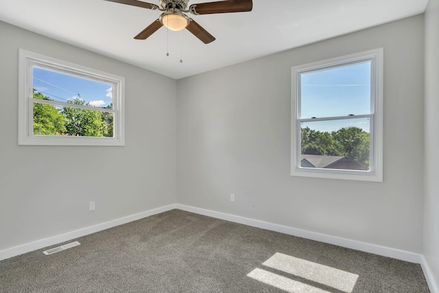 unfurnished room with carpet flooring, baseboards, visible vents, and ceiling fan