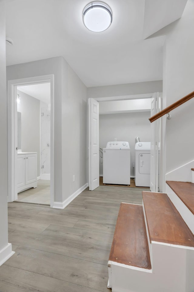 interior space with washer and dryer, stairs, baseboards, and wood finished floors