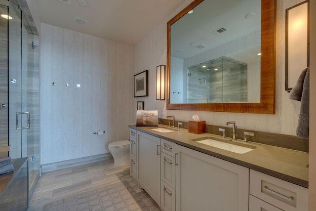 full bath with a sink, visible vents, a shower stall, and wallpapered walls