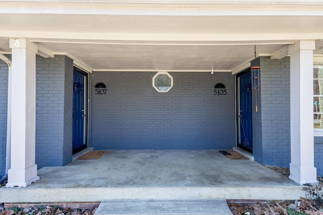 doorway to property featuring an attached carport and a porch