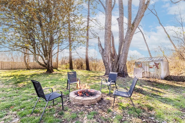 view of yard with an outbuilding, a storage unit, fence, and an outdoor fire pit