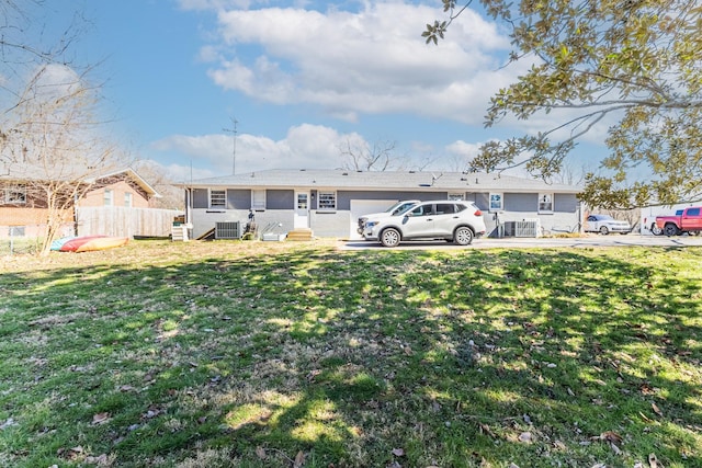 rear view of house with a yard, entry steps, central AC, and fence