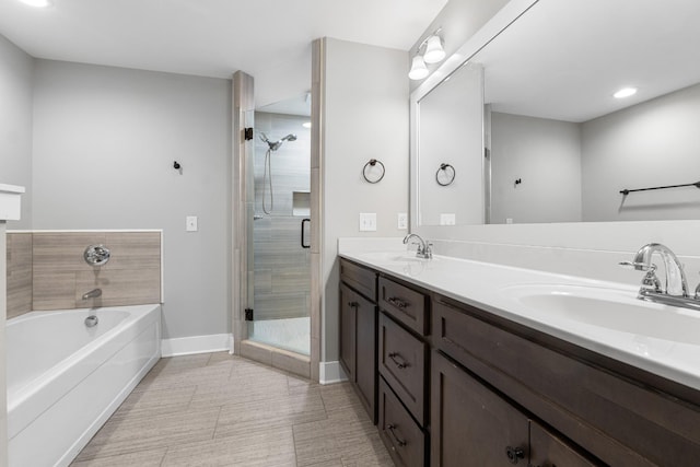 bathroom featuring a sink, a garden tub, a stall shower, and double vanity