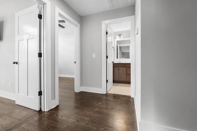 corridor with visible vents, baseboards, and wood finished floors