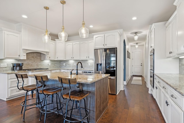 kitchen with white cabinets, dark wood-style flooring, appliances with stainless steel finishes, and a sink