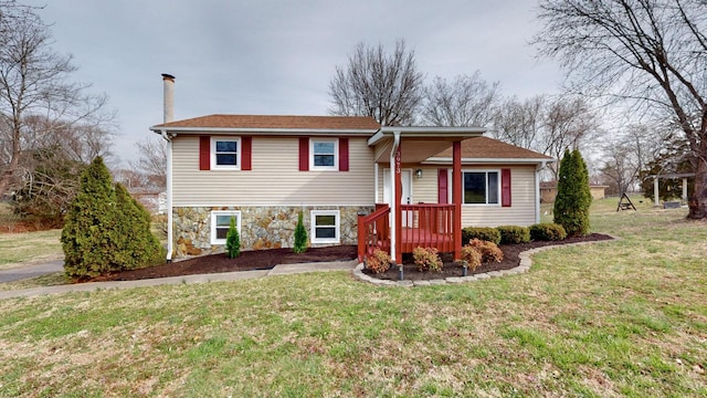 tri-level home featuring stone siding and a front lawn