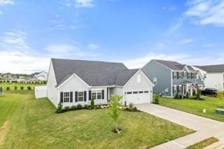 view of front of house with a front lawn, concrete driveway, and an attached garage