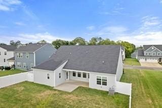 back of property featuring a yard, a patio area, fence, and a residential view