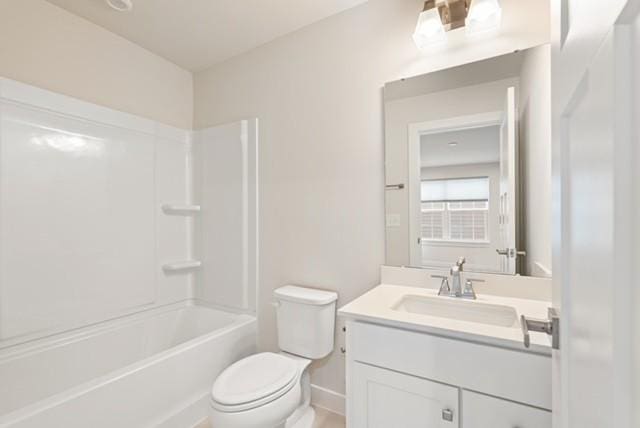 full bathroom with baseboards, shower / bathtub combination, toilet, and vanity