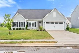 view of front of home with a garage, concrete driveway, and a front lawn