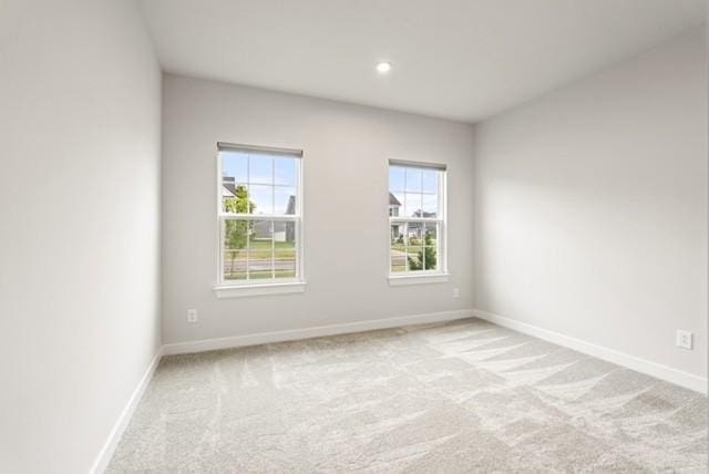 spare room with carpet flooring, recessed lighting, and baseboards