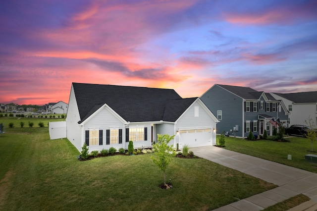 view of front of home with a lawn, driveway, and a garage