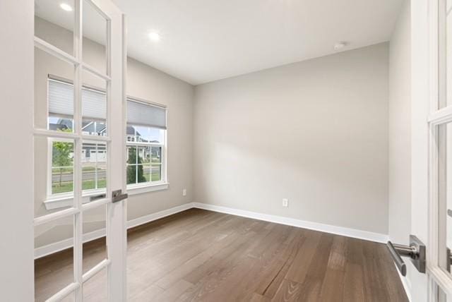 spare room with recessed lighting, baseboards, and dark wood-style floors