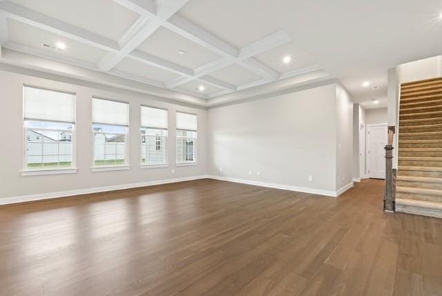 unfurnished living room with dark wood finished floors, stairway, coffered ceiling, and baseboards