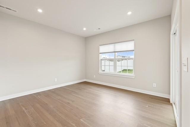 spare room with visible vents, recessed lighting, baseboards, and wood finished floors