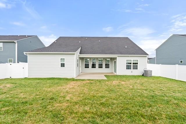 rear view of house featuring a patio area, central air condition unit, a lawn, and a fenced backyard