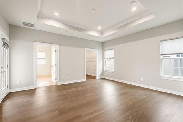 unfurnished room featuring visible vents, recessed lighting, a raised ceiling, and wood finished floors