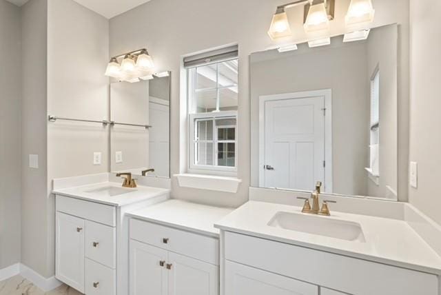 full bath featuring vanity and baseboards