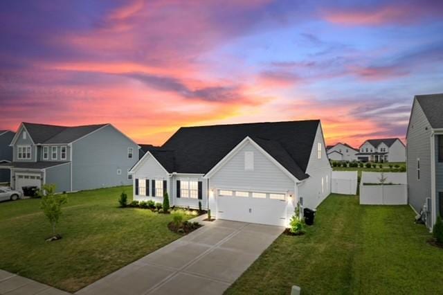 view of front of home with concrete driveway, a garage, and a front lawn