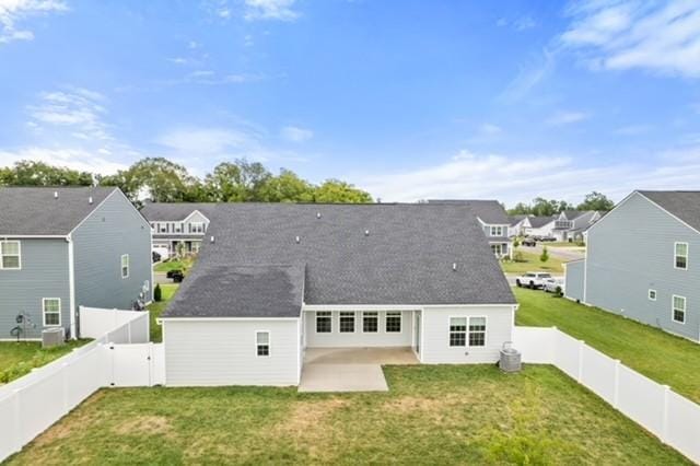 back of property featuring a yard, a residential view, a fenced backyard, and a patio area