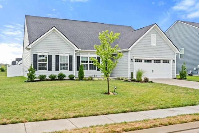 view of front of home with concrete driveway, a garage, and a front yard