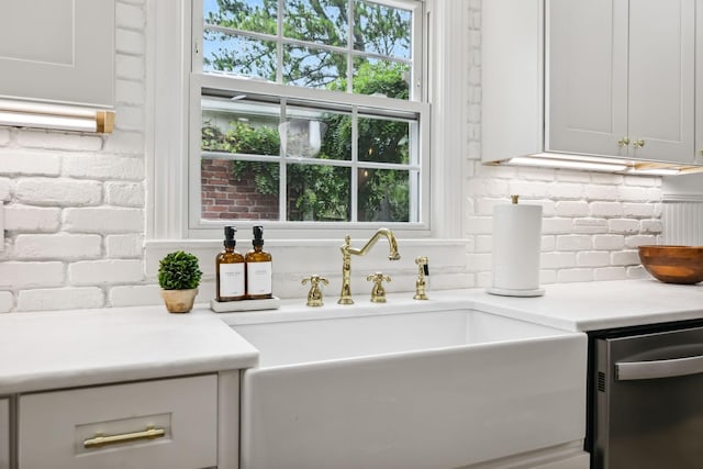 interior space with stainless steel dishwasher, light countertops, tasteful backsplash, and a sink