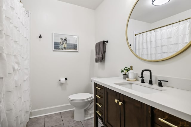 bathroom featuring tile patterned floors, toilet, vanity, and baseboards