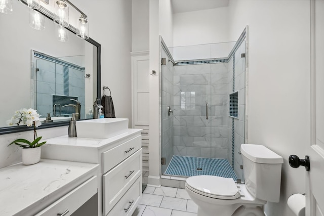 bathroom featuring toilet, marble finish floor, a stall shower, and vanity